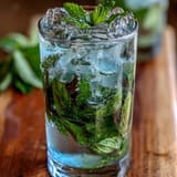 Vibrant Mint Julep Mocktail featuring bright mint syrup, lemon juice, and crushed ice, served in classic julep cups for Southern charm.