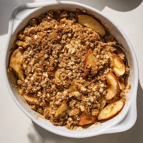 Freshly baked Apple Crumble with spiced apples bubbling under a golden, crispy oat topping.