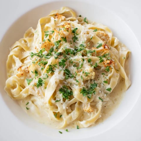 Golden roasted cauliflower florets blend into a creamy sauce over fettuccine, topped with fresh parsley and extra Parmesan.  