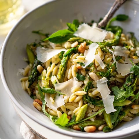 Bright shaved asparagus ribbons and tender orzo pasta are tossed with Parmesan and a zesty lemon-olive oil dressing in this vibrant Asparagus Lemon Orzo Salad.