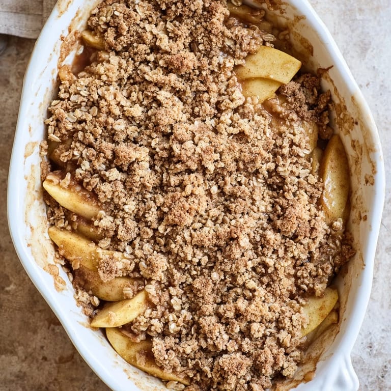 Close-up of Apple Crumble showing tender apple slices and buttery crumbly pieces in a baking dish.