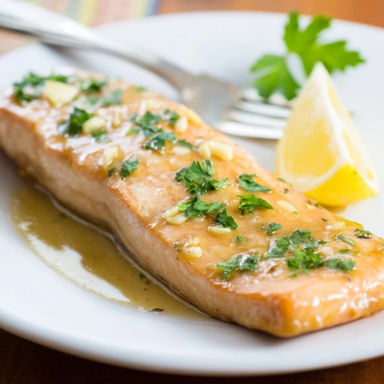 Perfectly roasted Honey Garlic Glazed Salmon fillets, tender and flaky, brushed with glossy glaze and finished with vibrant parsley and bright lemon wedges.