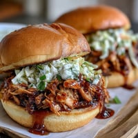 1. Juicy pulled BBQ chicken piled high on a soft brioche bun, topped with creamy coleslaw for the ultimate summer sandwich.  